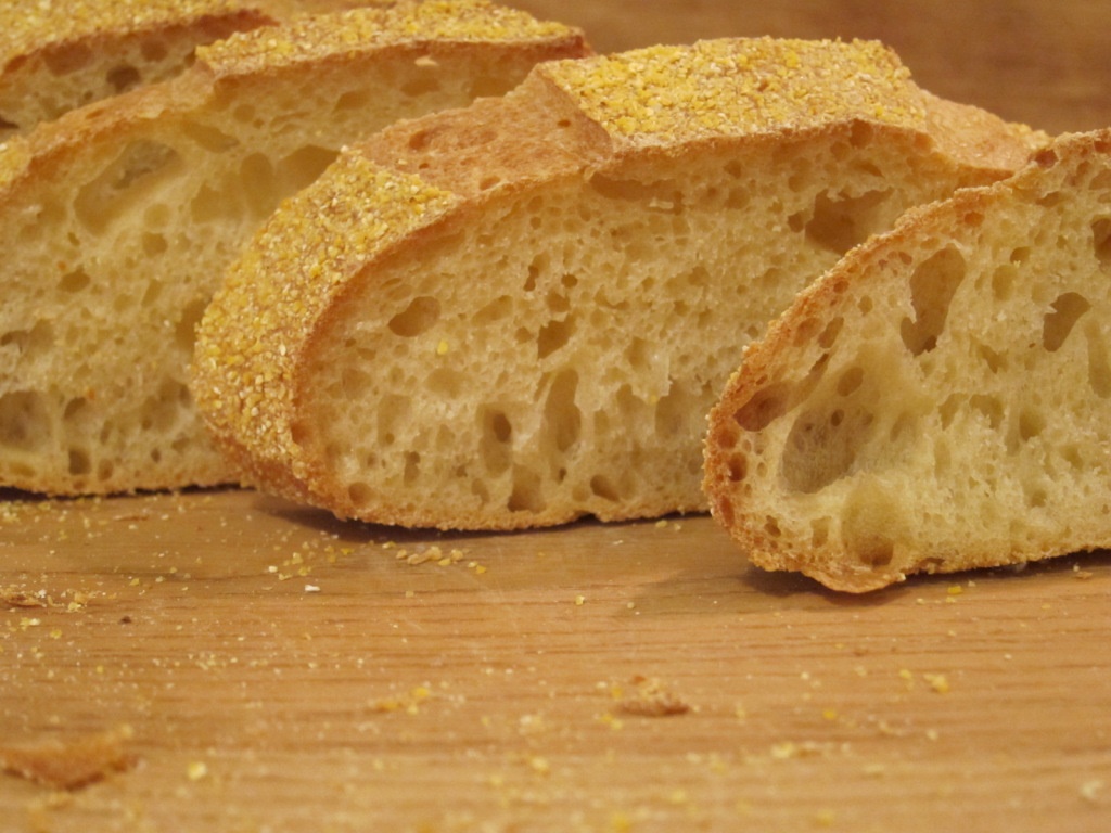 Nahaufnahme von aufgeschnittenem Ciabatta-Brot mit einer goldenen Kruste und einer lockeren, luftigen Krume.