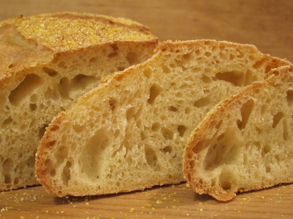Nahaufnahme von frisch gebackenem Ciabatta-Brot, in Scheiben geschnitten, mit einer golden-braunen Kruste und luftiger, offener Krume.