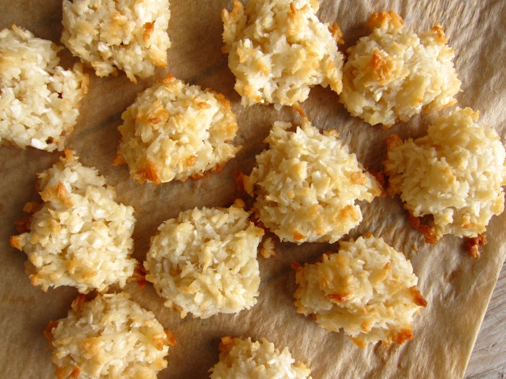 Kokosmakronen auf einem Backpapier, goldbraun und knusprig.