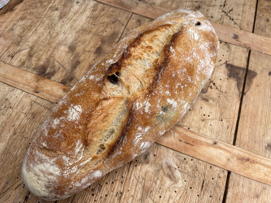 Ein frisch gebackenes Brot auf einer hölzernen Oberfläche.
