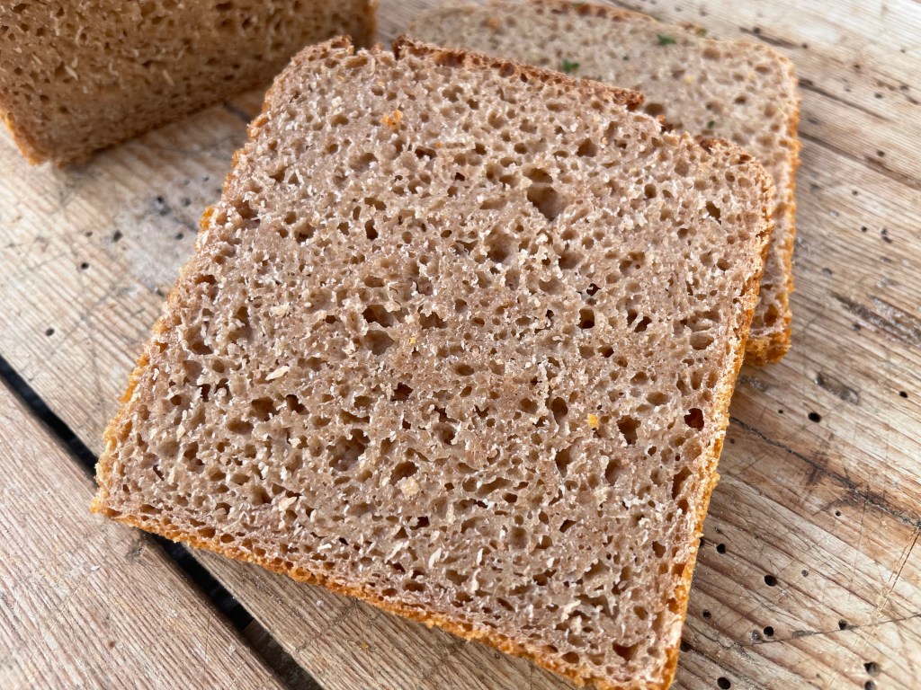 Eine Scheibe Vollkornbrot auf einem Holzuntergrund.